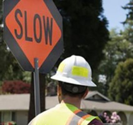 Worker holding a slow down traffic sign
