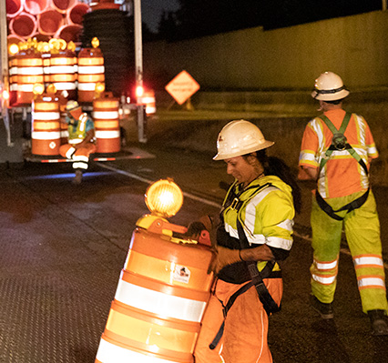 Road work team placing traffic safety equipment on the road